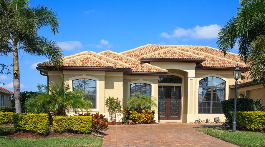 one floor florida home with tile roof and paver driveway
